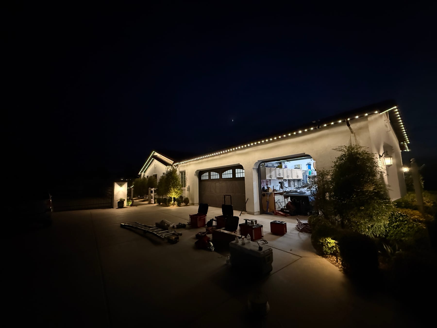 Warm white exterior lighting installed along a home roofline